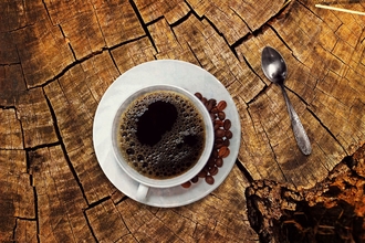 Cup of coffee on tree trunk