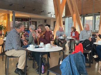 A dozen people sat at small tables talking animatedly in groups 