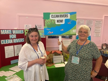 Two ladies with rivers banner