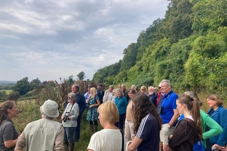 Group of people outside with tall trees behind