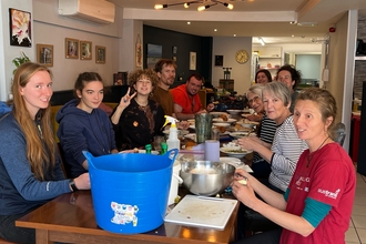 People sat around a long table preparing food