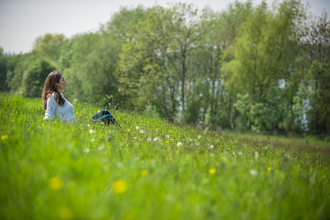 Young woman taking time out to relax in a beautiful summer meadow