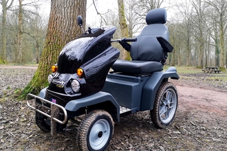 'Tramper' electric mobility vehicle beside a tree in winter woodland