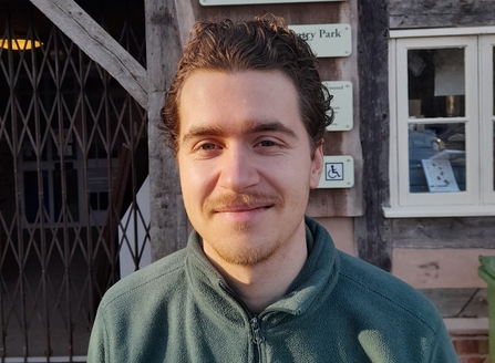 Portrait of man in green fleece with brown hair looking at camera