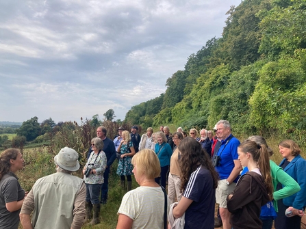 Group of people outside with tall trees behind