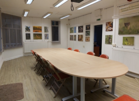 View of room with large table with chairs around it; white walls with wildlife photos